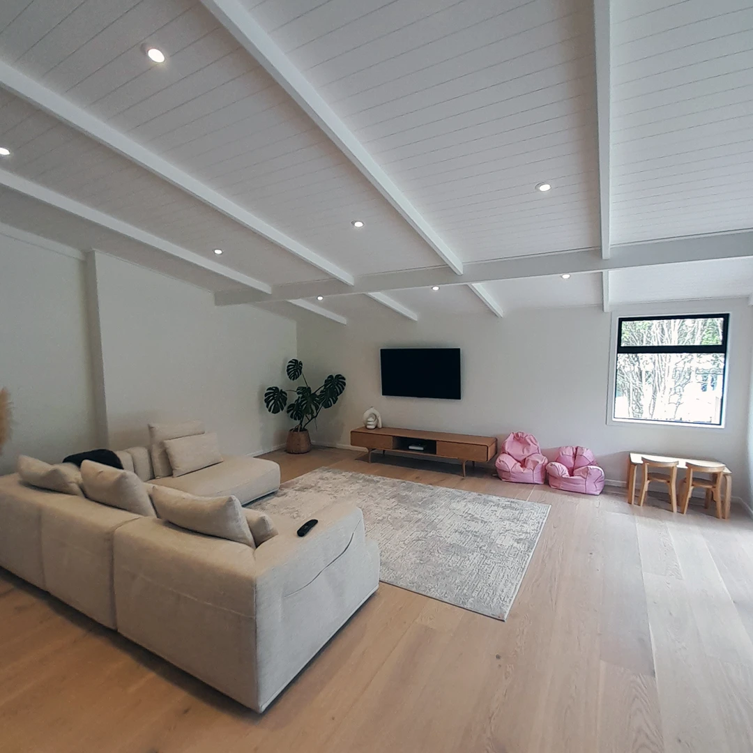 Relaxing lounge area with a couch, television, and chair in a stylish living room.
